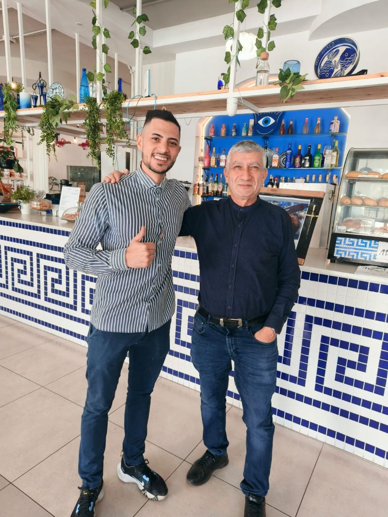 Guests smiling in front of the Meraki bar