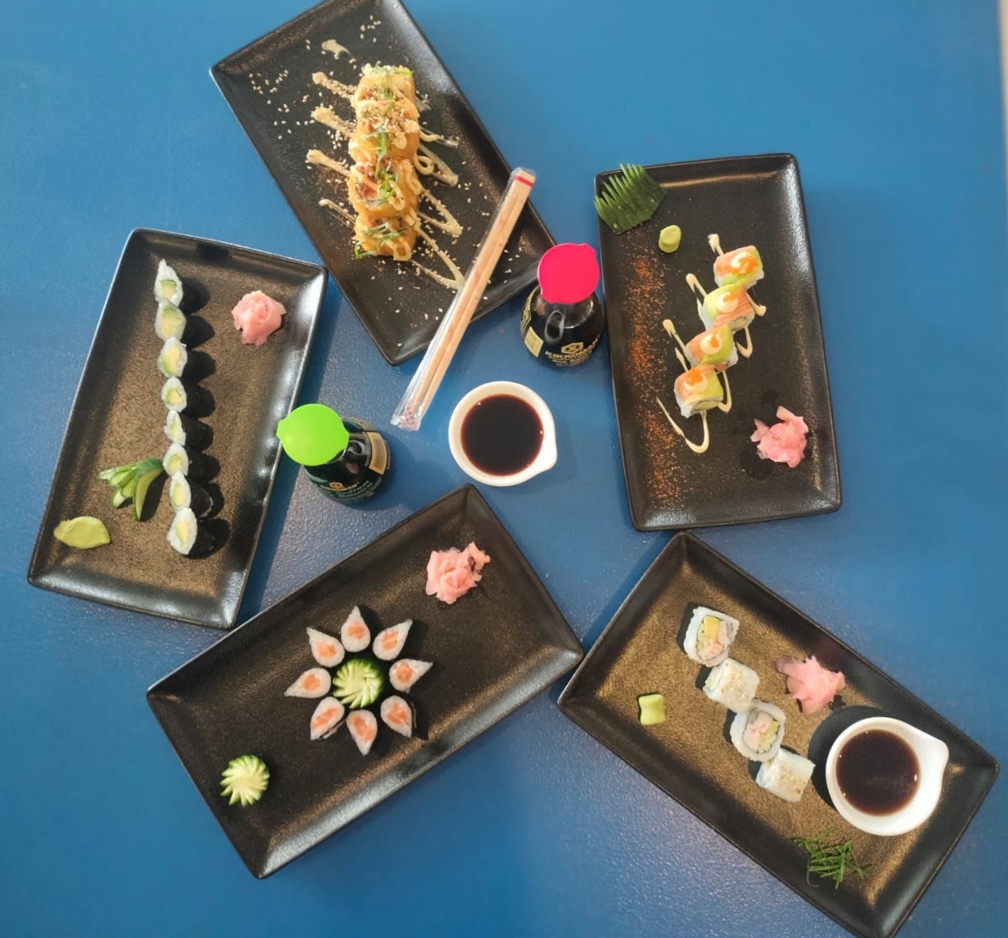 Spread of sushi plates with soy, ginger and wasabi
