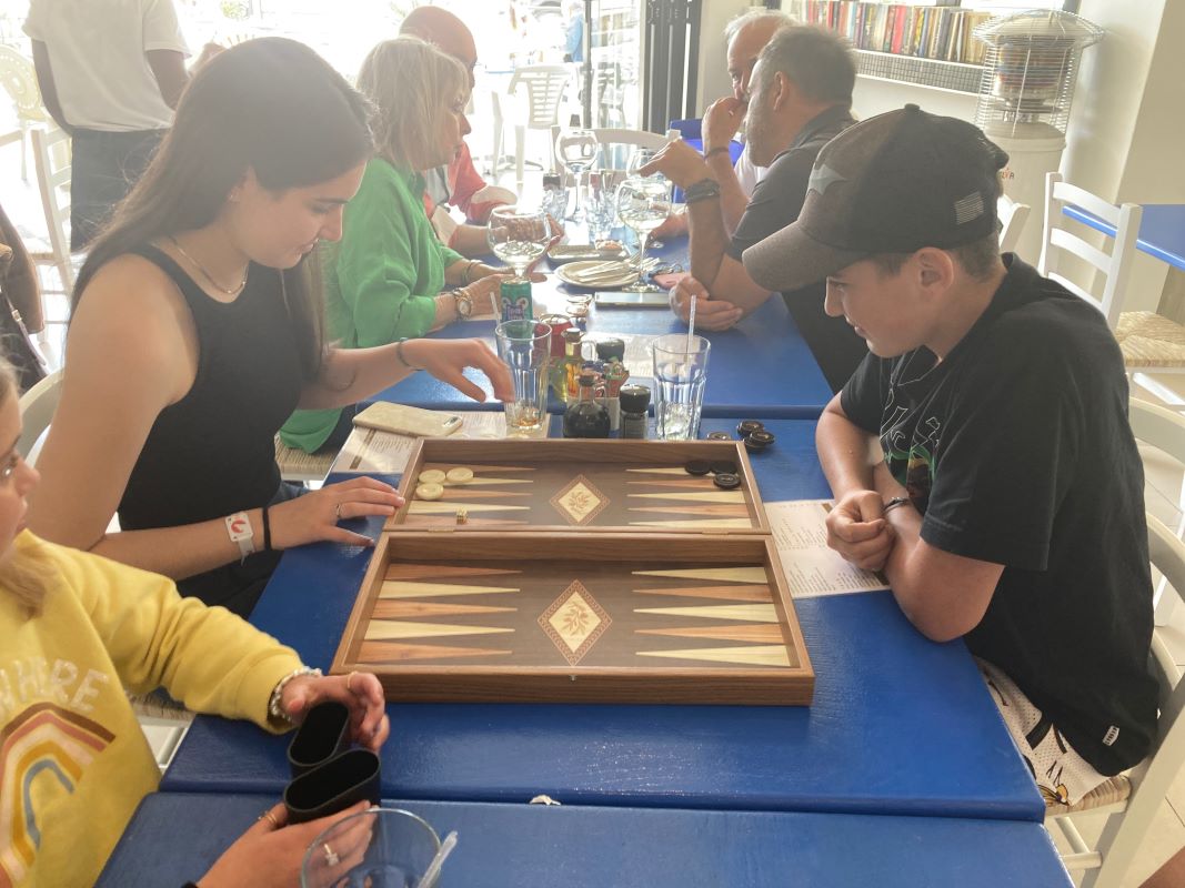 Guests playing tavli at the blue tables