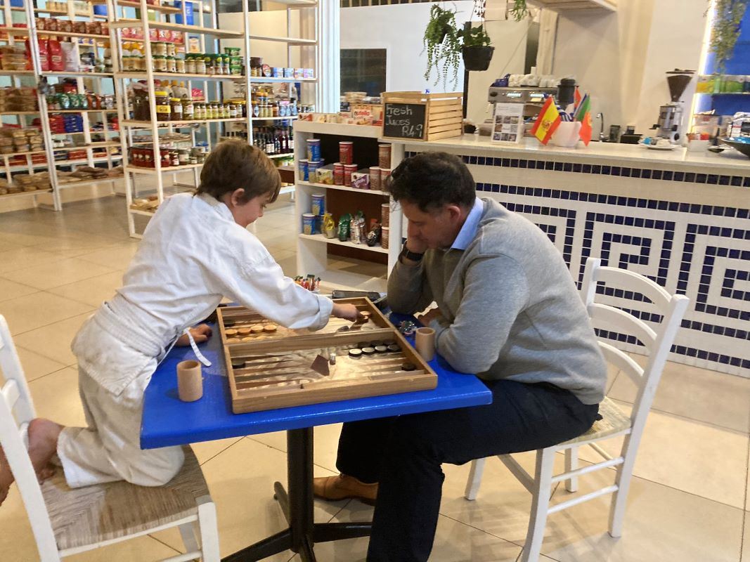 Father and son playing tavli in the deli