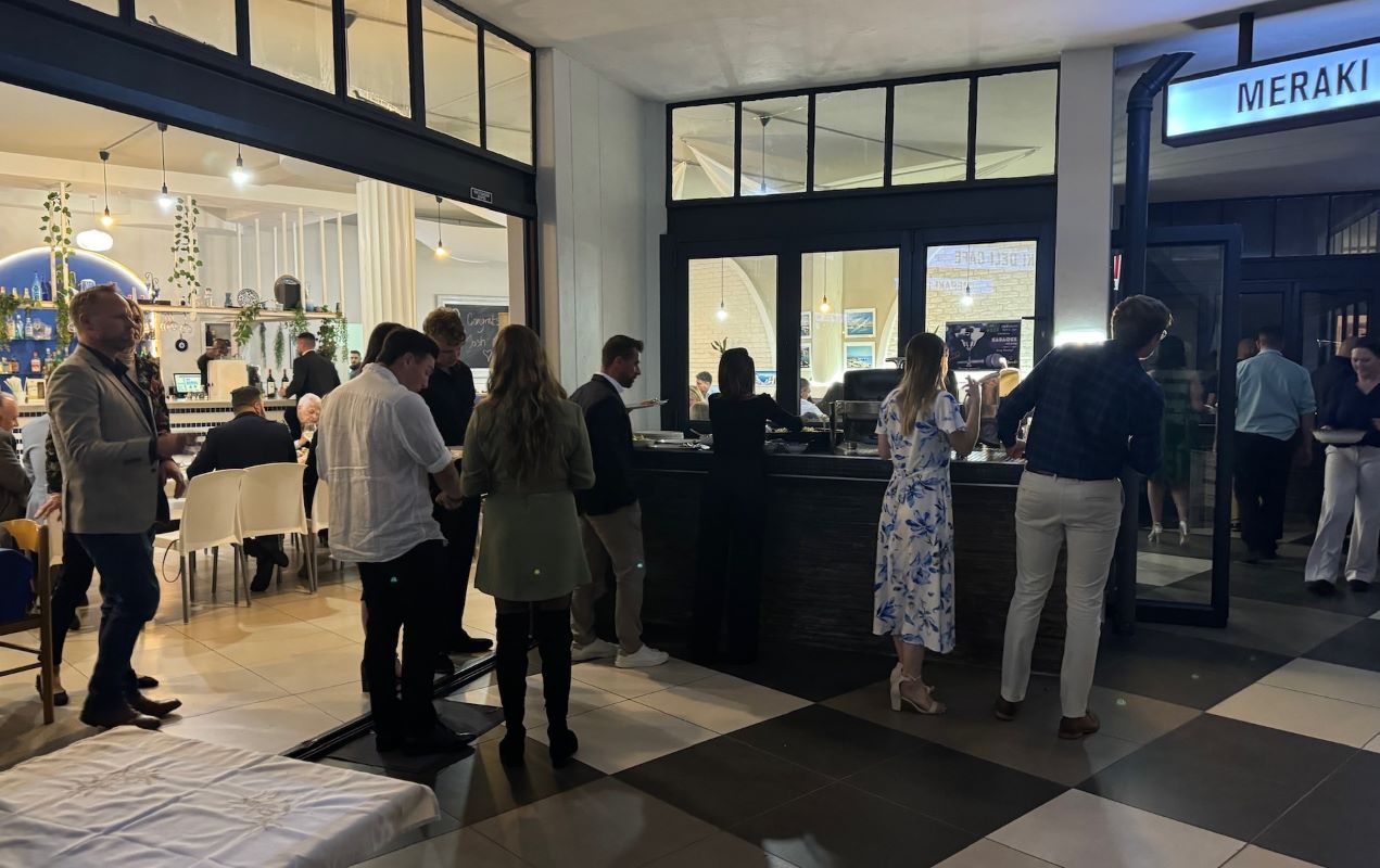 Guests gathered at the buffet under the Meraki sign