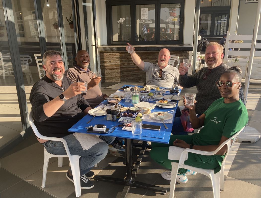 Friends raising a toast around a blue table