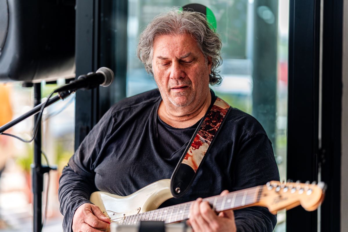 Live guitarist performing at Meraki Deli Cafe