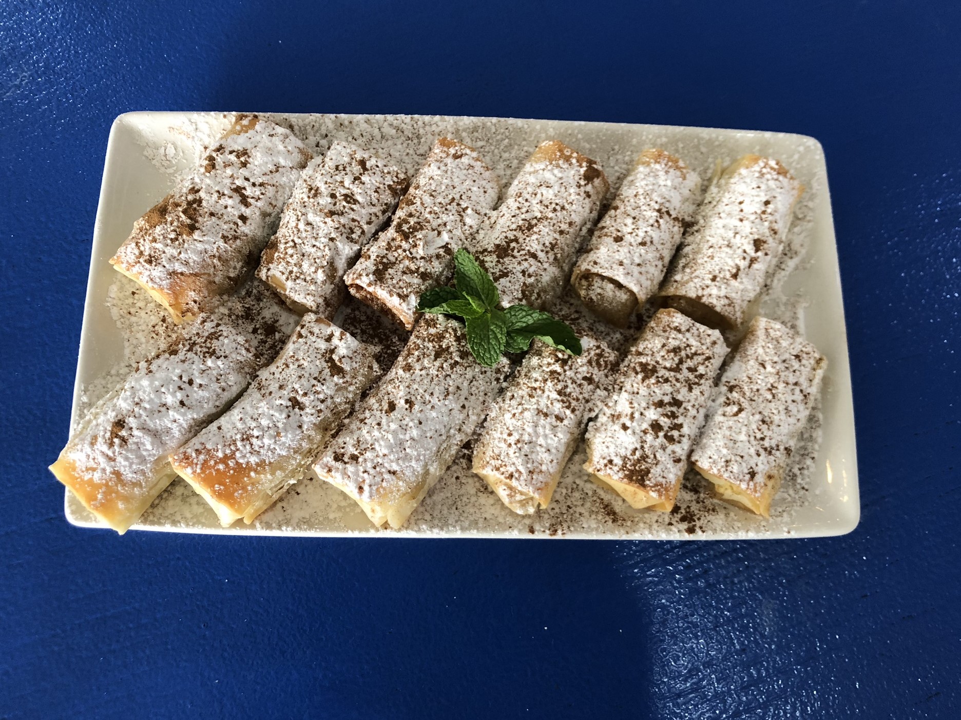 Bougatsa rolls dusted with cinnamon and icing sugar